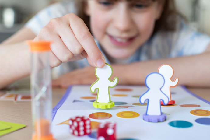 Menina jogando um jogo de tabuleiro de conhecimentos gerais