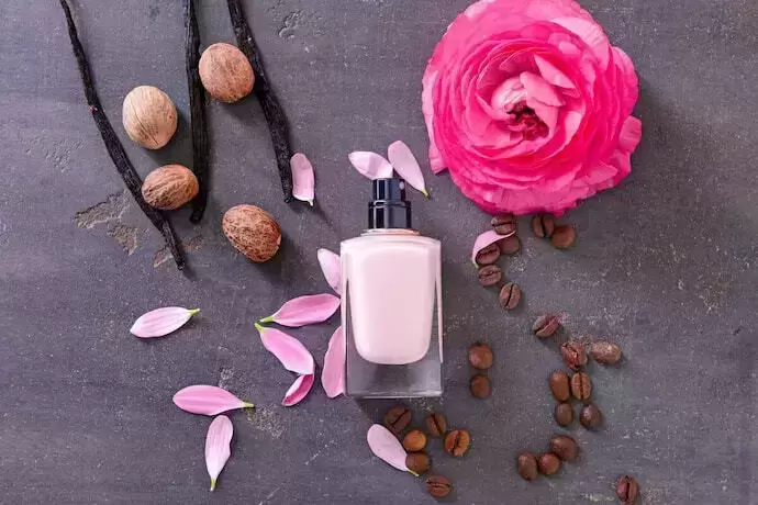 Perfume com rosas e sementes no fundo 