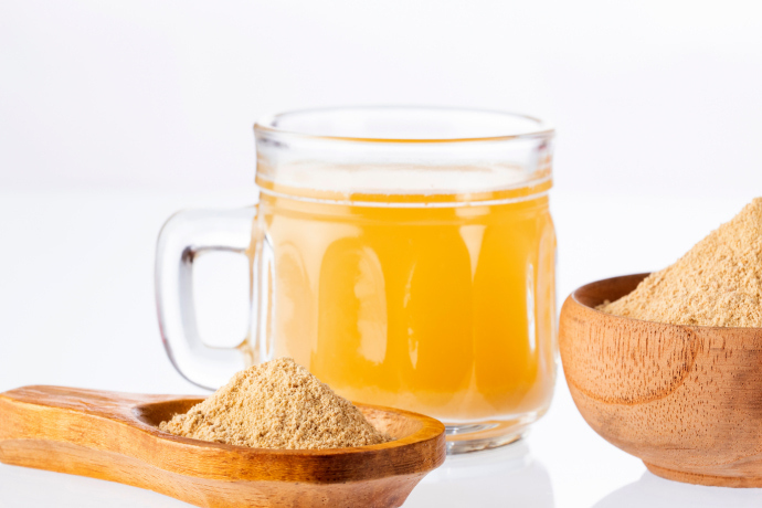 Maca peruana em pó e um copo de suco de laranja