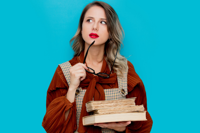 Mulher segurando alguns livros em um fundo azul