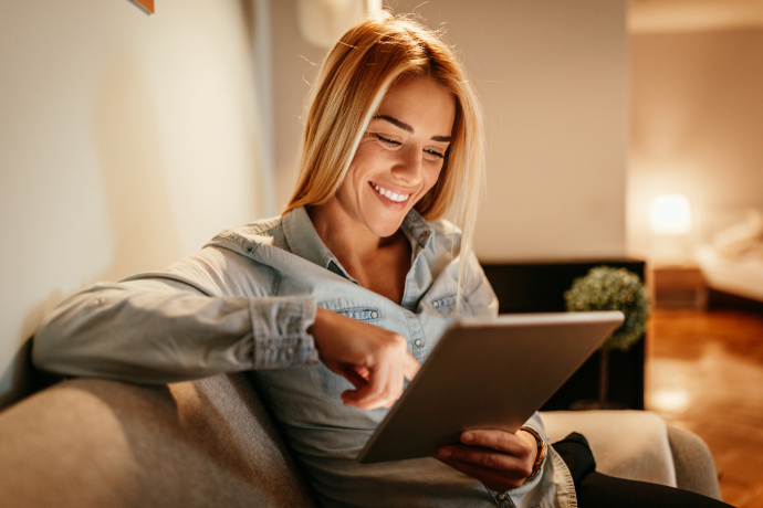 Mulher lendo um e-book na sala de estar