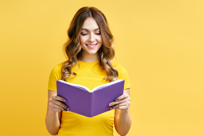 Mulher lendo um livro em um fundo amarelo 