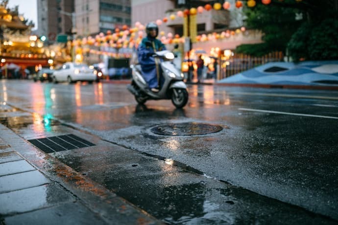 Motoqueiro com capa de chuva azul