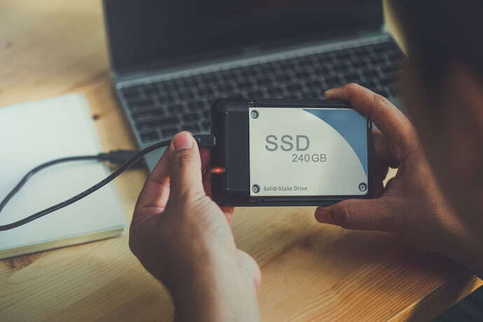 Homem instalando um SSD no notebook