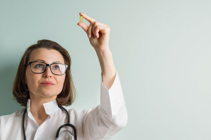 Médica segurando uma vitamina. 