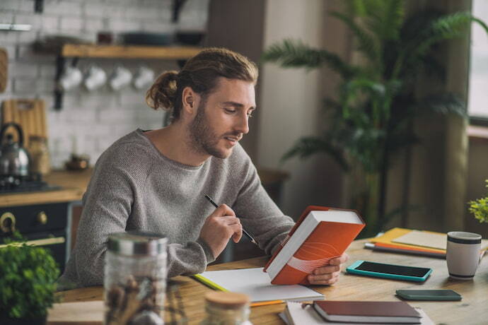 Um homem com um livro de gramática